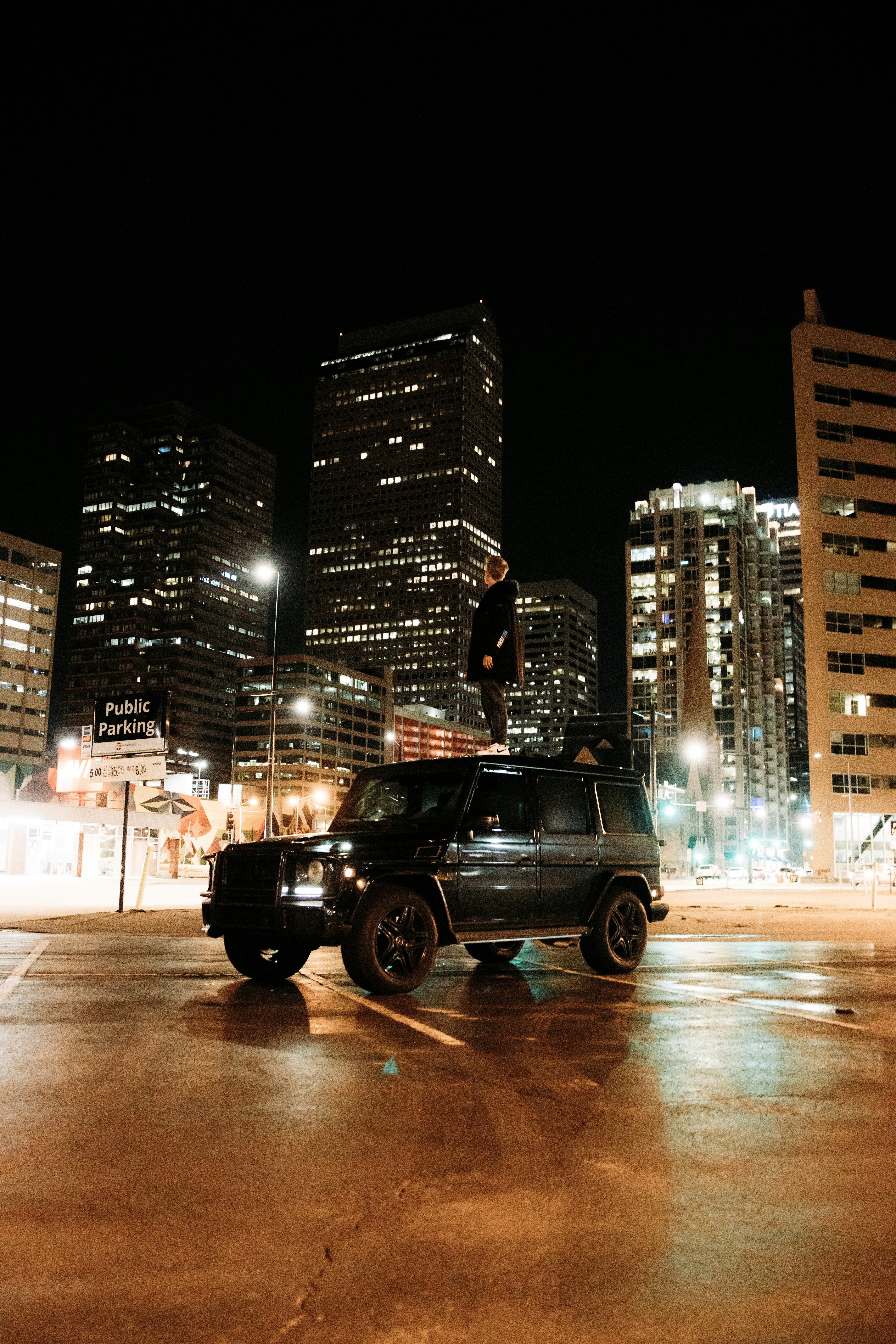 black suv on road near high rise buildings during night time